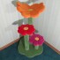 Shown here with bright orange, bright red, & pink flowers w/ grass green base & posts.